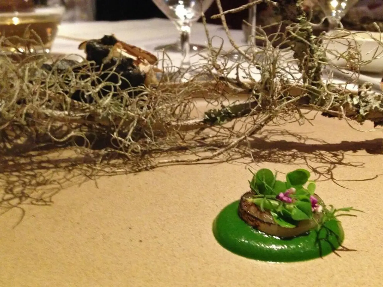 In this image I can see there is some food places in the plate and there are few wine glasses...