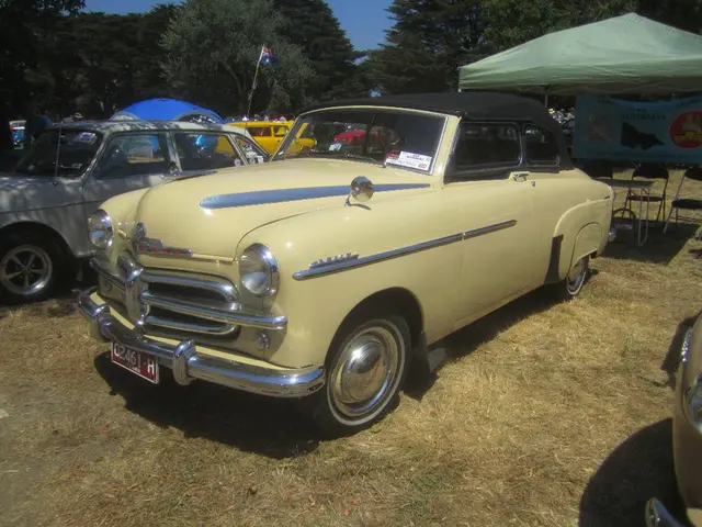 In this image, we can see some cars. There is a table and some chairs on the right side of the...